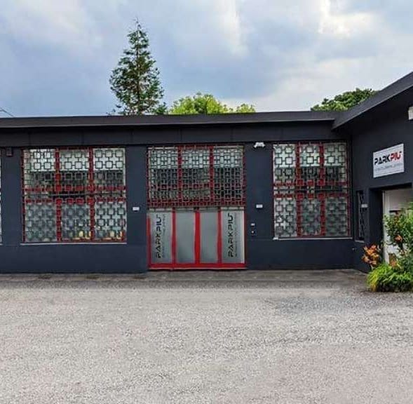 PARKPIÙ structure - black building with red doors and grid windows