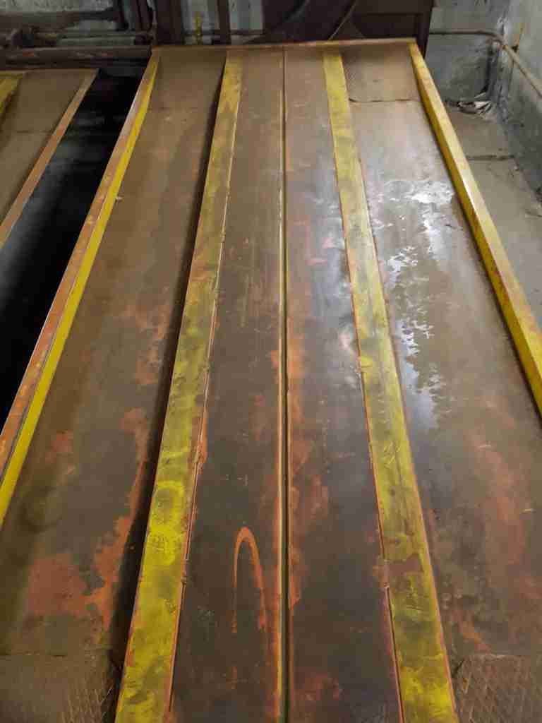 Automatic parking interior before renovation - rusty yellow and red platforms, dirty walls, poor lighting